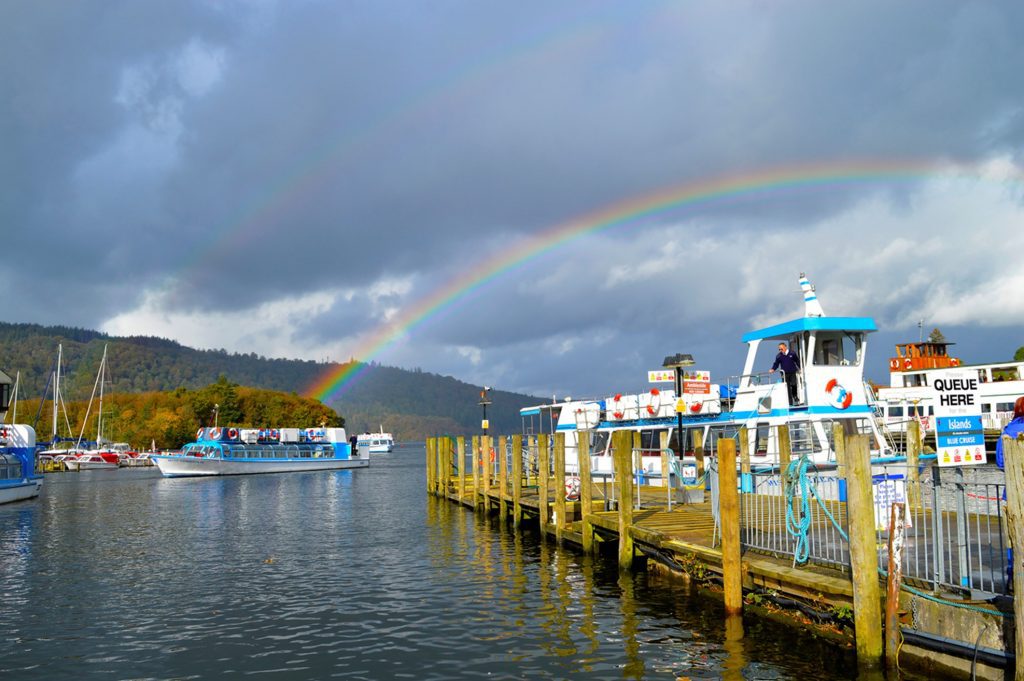 lots of boast with cloudy weather with rainbow in the backgroud